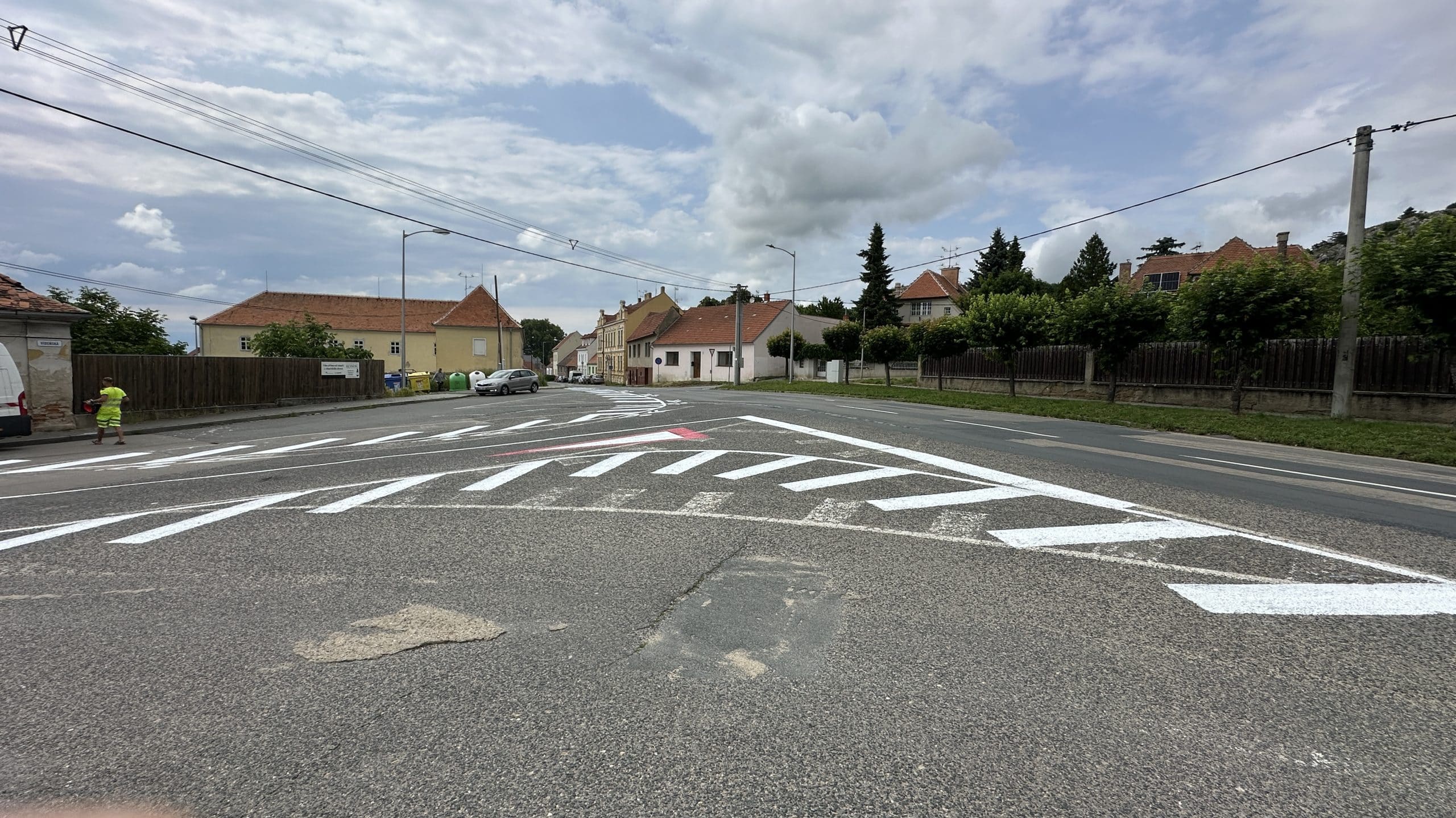 Realizace vodorovného dopravního značení bílou barvou a barevné symboly.